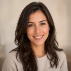 Portrait d’une jeune femme brune souriante pour illustrer une cliente d’Amigos de Milou.